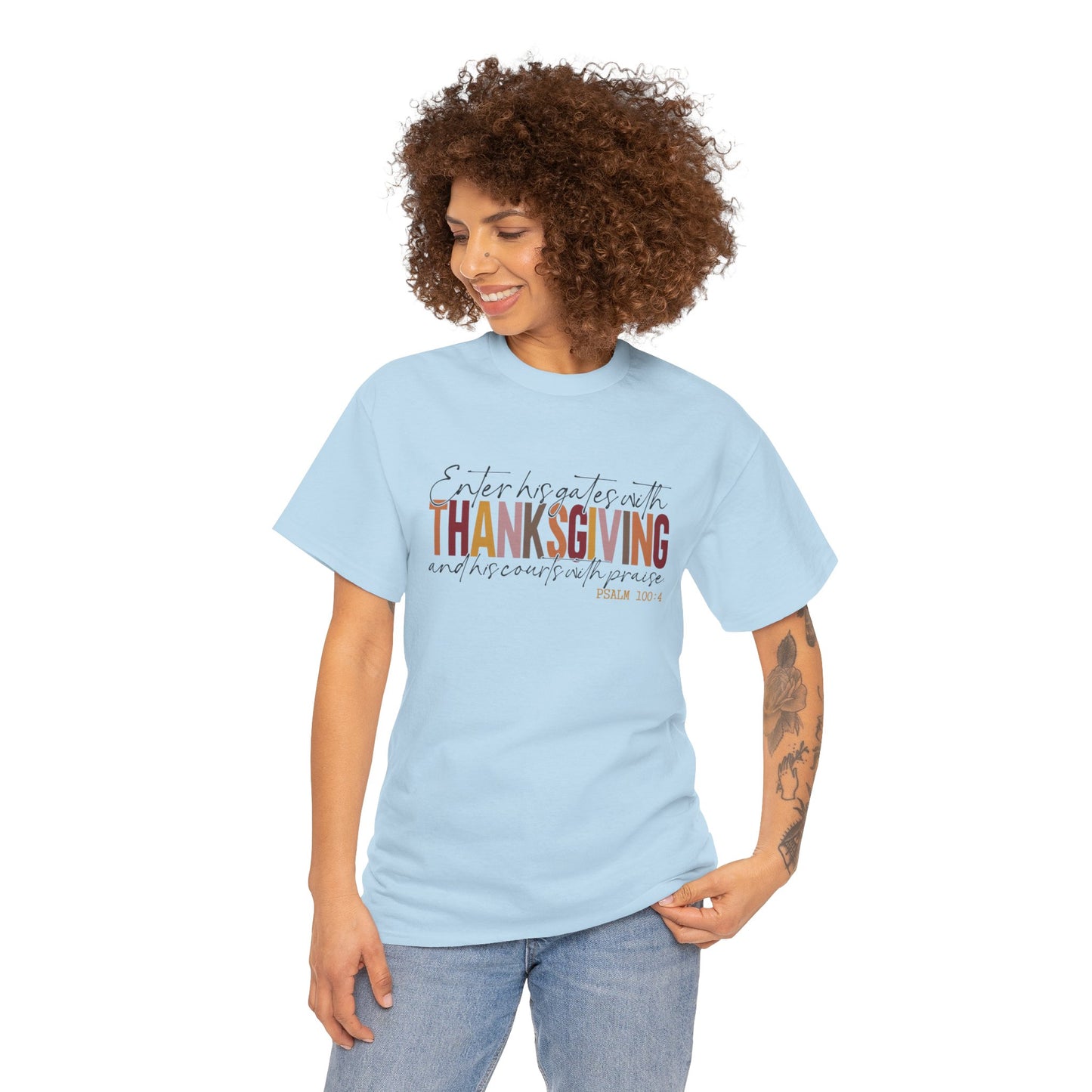 Woman wearing a white t-shirt that reads “Enter His Gates with Thanksgiving – Psalm 100:4,” styled with jeans, Christian faith-inspired fall outfit.